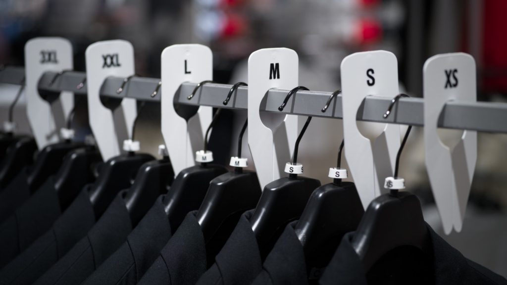 Rack dividers for organized apparel displays by Mark Bric Sizers in a retail store setting.