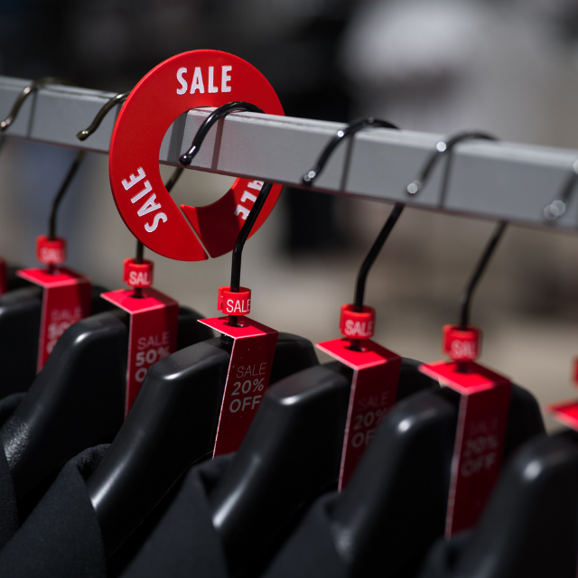 A rack in a store with size markers, size tags and rack dividers.